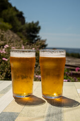 Two glasses of fresh cold lager beer served outdoor in snack bar with view on Calanque de Figuerolles in La Ciotat, Provence, France