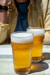 Men with two glasses of fresh cold lager beer in French outdoor cafe