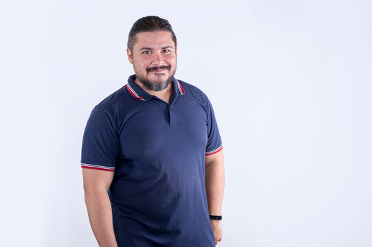 A bearded chubby man of mixed ancestry in his 30s. Wearing a blue polo shirt. Isolated on a white background.