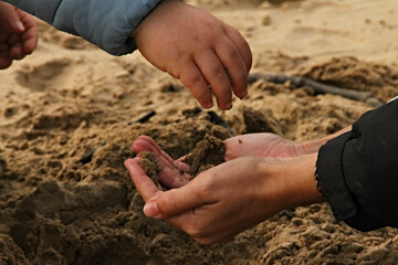 a hands play with the sand in the beach in Spain