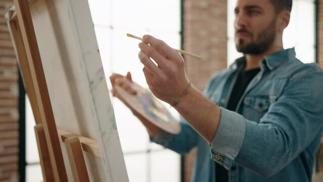 Young hispanic man concentrate drawing at art studio