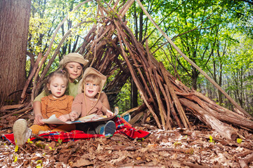 Three children sit with treasury map play treasure hunt