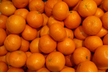 Many orange mandarins, on sale in the supermarket