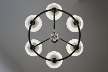 A metal ceiling light fixture with six lights 