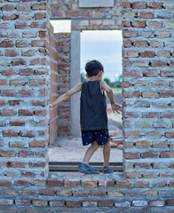 latino child playing inside a construction site outdoor. Future houses concept.