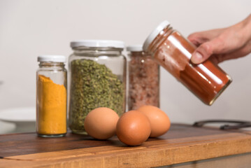 woman's hand holding colorful spices, eggs, healthy eating, selective focus