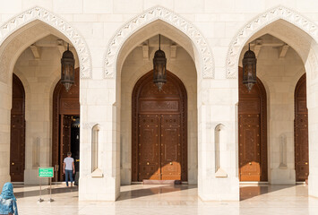 Obraz premium Arched gates and carved wooden doors leading to the Sultan Qaboos Grand Mosque, Oman, Middle East