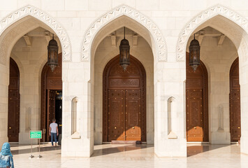 Arched gates and carved wooden doors leading to the Sultan Qaboos Grand Mosque, Oman, Middle East