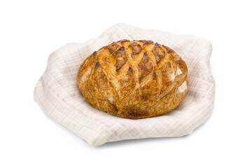 Loaf of baked wheat bread on linen napkin isolated on white background.