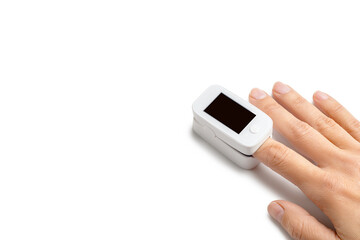 Pulse oximeter on finger to measuring saturation oxygen level and pulse rate isolated on white background, copy space.