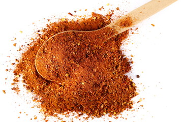 Spicy chili pepper flakes, crushed, milled dry paprika pile in wooden spoon isolated on white, top view