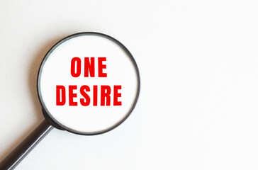 The text ONE DESIRE is written on a gray background. We read through a magnifying glass.
