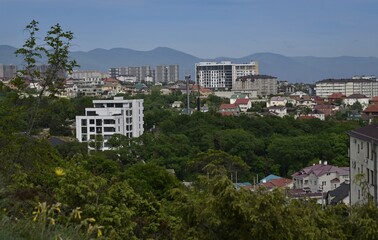 Obraz premium A beautiful panoramic view from the height of the mountains to the village of Myskhako on the Black Sea coast. Blue sky. Green grass. High mountains. Novorossiysk.Russia.