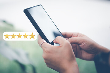 Customer Satisfaction Survey Concept, A woman's hand using a smartphone gives a 5 star rating to...