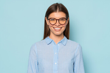 Confident smiling female office worker in trendy glasses isolated over blue copy space background