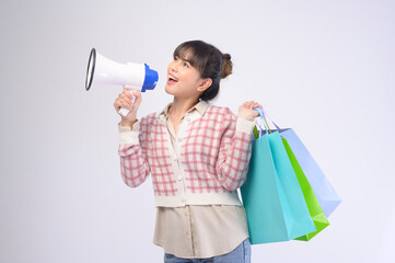 Attractive shopper woman holding shopping bags over white background