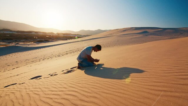 Tired lonely man struggles in the desert with empty bottle of water