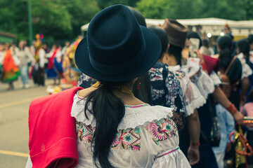 Naklejka premium Ecuadorian indigenous men and women dressed in their typical costumes celebrate the cult of the sun god, Inti Raymi, surrounded by fruit and typical food.