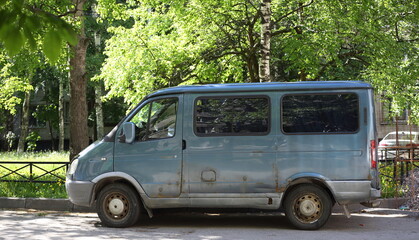 An old rusty blue minibus parked in the courtyard, Antonova-Ovseenko Street, St. Petersburg, Russia, May 2022