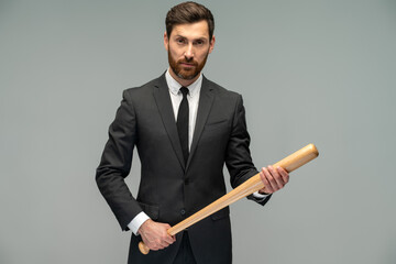 Waist up portrait view of the caucasian businessman with a baseball bat standing over grey background. Occupation concept