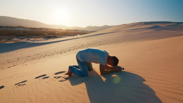 Tired lonely man struggles in the desert with empty bottle of water