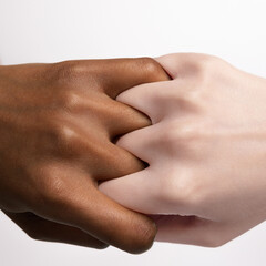 Finger grip. Closeup female hands and fingers holding each other isolated on grey studio...