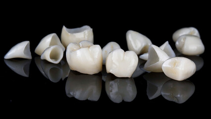 composition of dental crowns and veneers on black glass with reflection