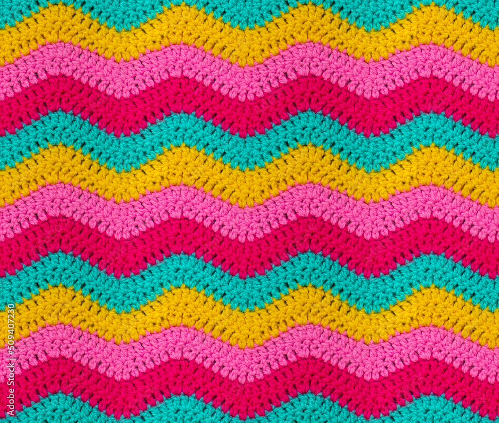 Wall mural seamless knitted pattern in the form of zigzags is crocheted with bright multi-colored threads. acry