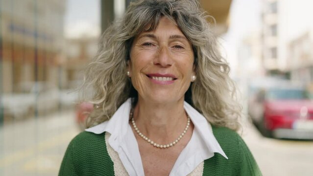 Middle age woman smiling confident standing at street