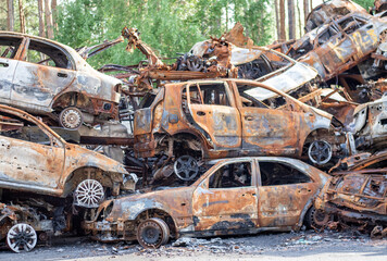 Rusty burnt cars destroyed by rocket explosions. War in Ukraine. Destroyed vehicles of civilians who were leaving were evacuated from the combat zone from Bucha and Irpin. Car graveyard.