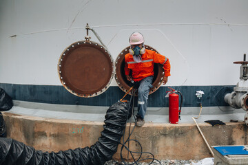 Male worker into the tank carbon chemical oil interface area confined