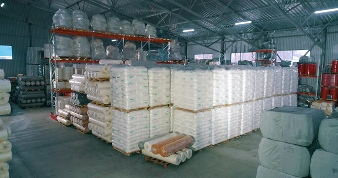 Warehouse of raw materials at the factory. Lots of raw material bag for production. Spunbond in rolls in the warehouse of the factory