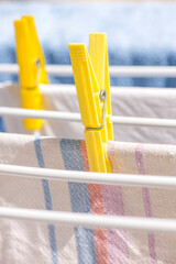 Laundry hanging to dry on clothesline, closeup on yellow clothespin