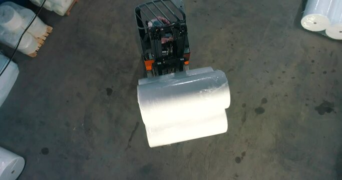 The forklift transports non-woven materials. The forklift transports rolls of agrofibre