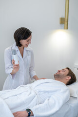 Female cosmetologist holding a bottle with cream