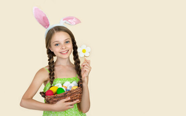 Little girl with colorful easter eggs, little rabbits and flower cookie smiling to the camera. Easter decoration.