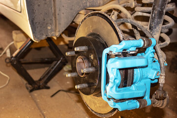 Vehicle disc brake for repair, in the process of replacing new tires. Repair of car brakes in the...