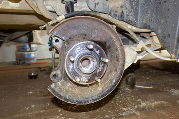 Vehicle disc brake for repair, in the process of replacing new tires. Repair of car brakes in the garage.