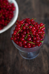 Currants in a bowl on a weeden background. Red berry. Vitamin berries. Copy space.