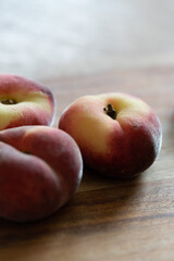 Plattpfirsiche auf einem Holzbrett