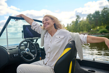 Blonde woman sitting in a boat and looking relaxed