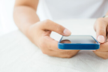 Closeup woman using smart phone on the table in the white environment, easy to use the phone concept