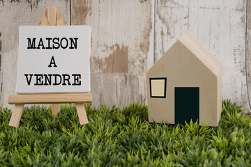 maison en bois à vendre avec un panneau sur un chevalet