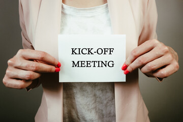 Businesswoman holding sheet of paper with text kick-off meeting. Teamwork, unity, partnership, new...