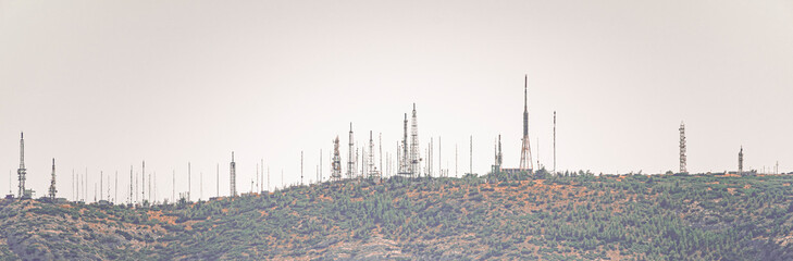 Panoramic of a mountain full of radio frequency and television antennas