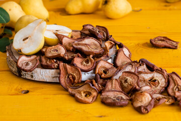 Slices of dried pears, delicious snack, healthy food, close-up on a wooden background