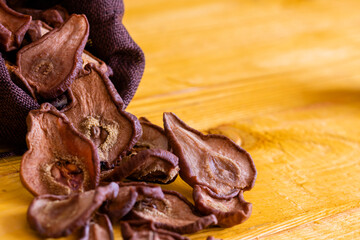 Slices of dried pears, delicious snack, healthy food, close-up on a wooden background