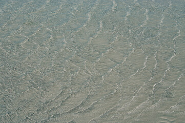 Ripples in shallow sea water background. Crystal clear water texture.
