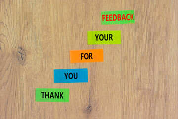 Thank you for feedback symbol. Concept words Thank you for your feedback on colored paper on a beautiful wooden table wooden background. Copy space. Business and thank you for feedback concept.