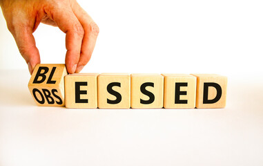 Blessed or obsessed symbol. Businessman turns wooden cubes and changes the concept word Obsessed to Blessed. Beautiful white table white background. Business blessed or obsessed concept. Copy space.